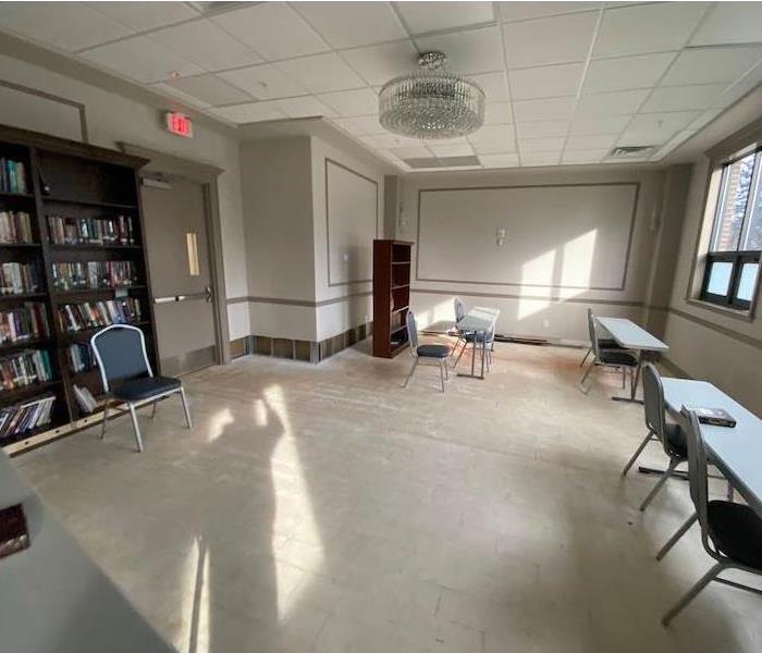 Room with tables and chairs with metal legs on concrete substrate