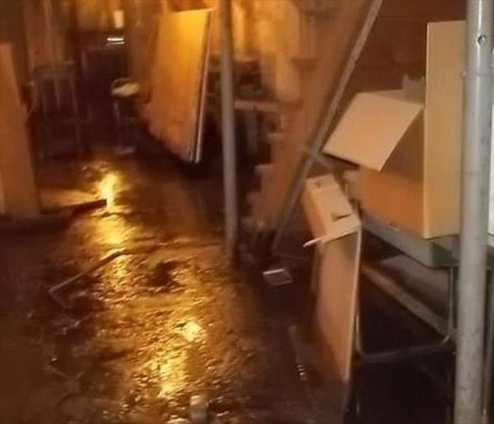 Basement with standing water on the floor and random items