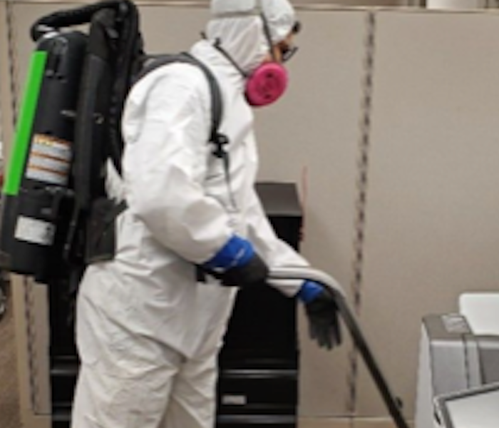 A male SERVPRO employee with a white hazmat suit on 